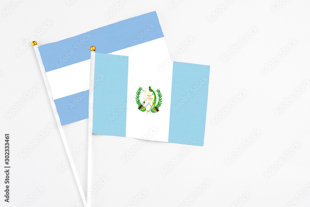Guatemala and Argentina stick flags on white background. High quality fabric, miniature national flag. Peaceful global concept.White floor for copy space. Guatemala and Argentina stick flags on white background. High quality fabric, miniature national flag. Peaceful global concept.White floor for copy space.
