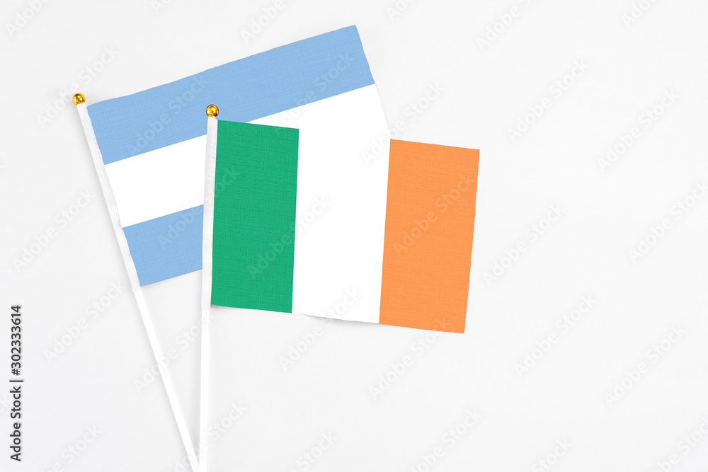 Ireland and Argentina stick flags on white background. High quality fabric, miniature national flag. Peaceful global concept.White floor for copy space. Ireland and Argentina stick flags on white background. High quality fabric, miniature national flag. Peaceful global concept.White floor for copy space.