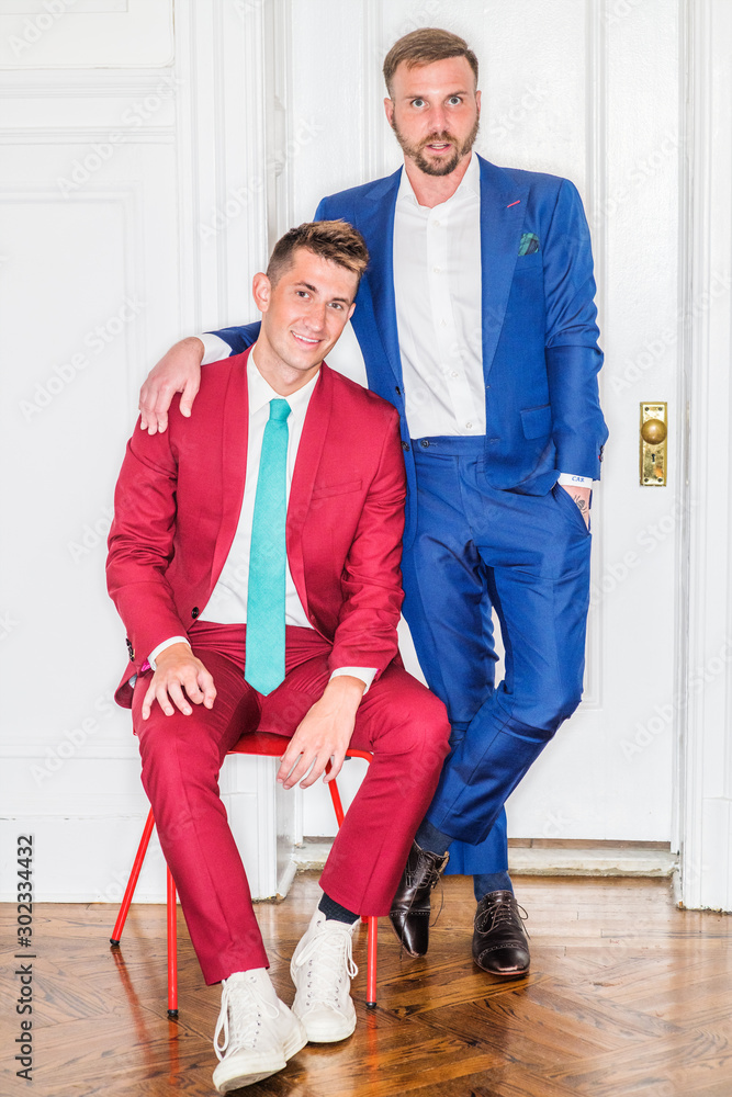 Young Businessmen Fashion in New York City. Two men - one wearing red suit,  white shirt, sneakers,