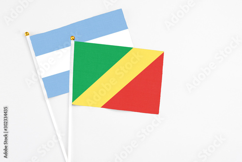 Republic Of The Congo and Argentina stick flags on white background. High quality fabric  miniature national flag. Peaceful global concept.White floor for copy space.