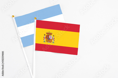 Spain and Argentina stick flags on white background. High quality fabric, miniature national flag. Peaceful global concept.White floor for copy space.