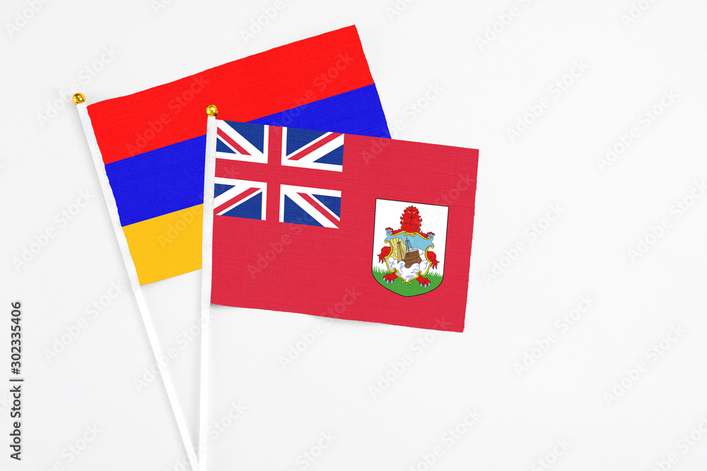 Fototapeta premium Bermuda and Armenia stick flags on white background. High quality fabric, miniature national flag. Peaceful global concept.White floor for copy space.