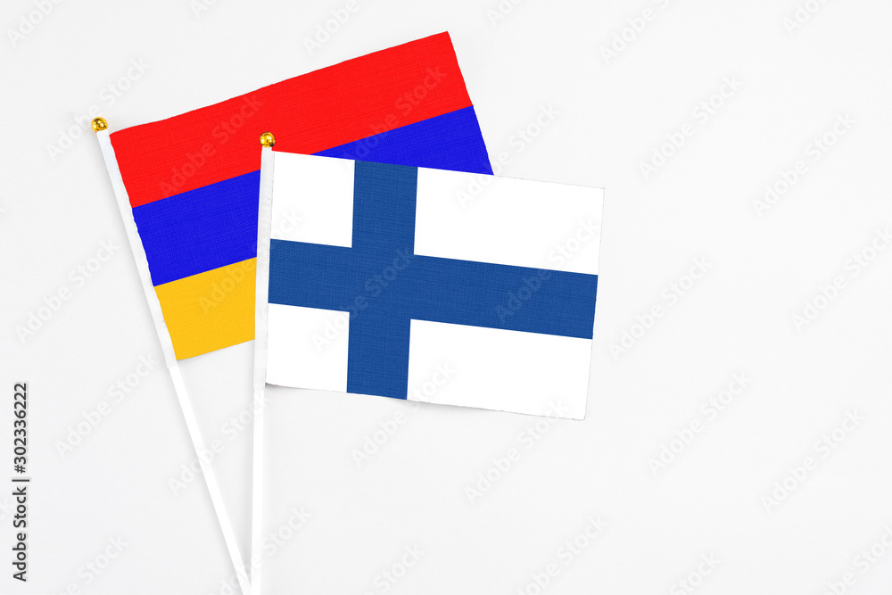 Finland and Armenia stick flags on white background. High quality fabric, miniature national flag. Peaceful global concept.White floor for copy space.