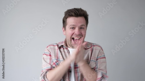 Young man smiling with glee as he rubs his hands together