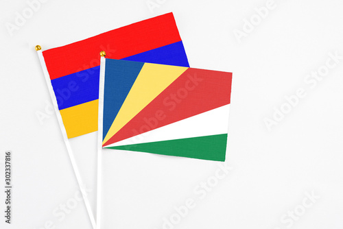 Seychelles and Armenia stick flags on white background. High quality fabric  miniature national flag. Peaceful global concept.White floor for copy space.
