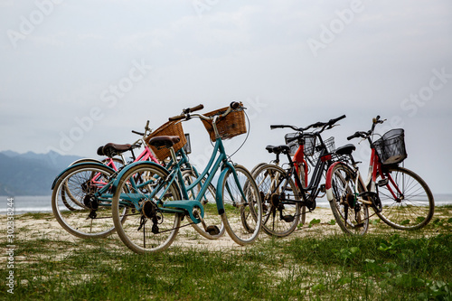 Walking bikes parked on the shore.