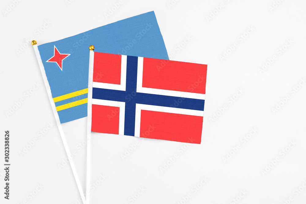 Bouvet Islands and Aruba stick flags on white background. High quality fabric, miniature national flag. Peaceful global concept.White floor for copy space.