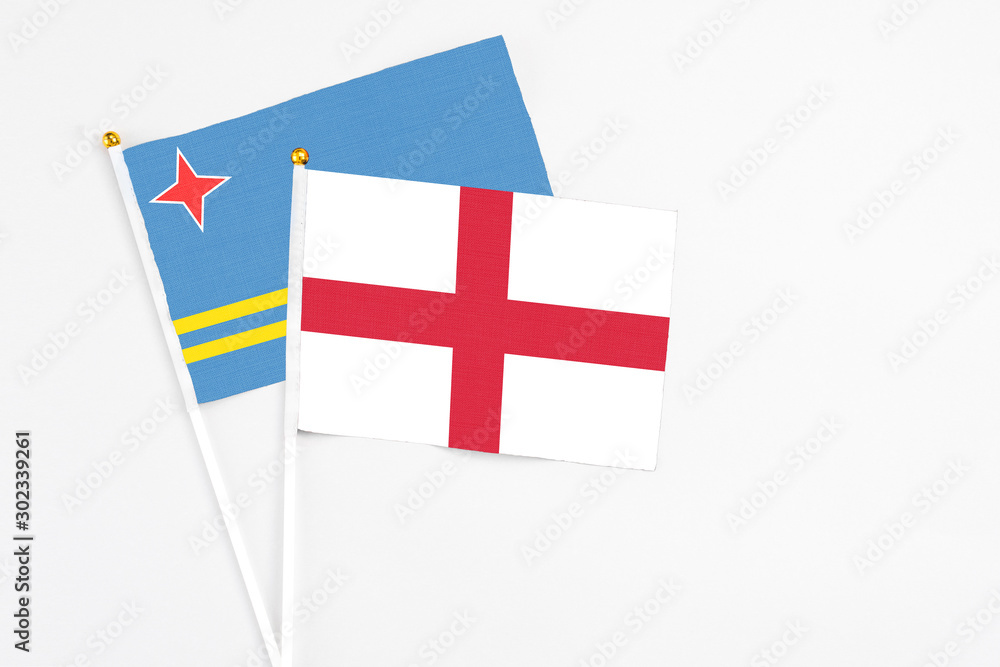 England and Aruba stick flags on white background. High quality fabric, miniature national flag. Peaceful global concept.White floor for copy space.