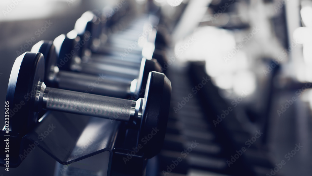 Fototapeta premium tło wnętrze siłowni z hantlami na stojaku w sali fitness i treningu