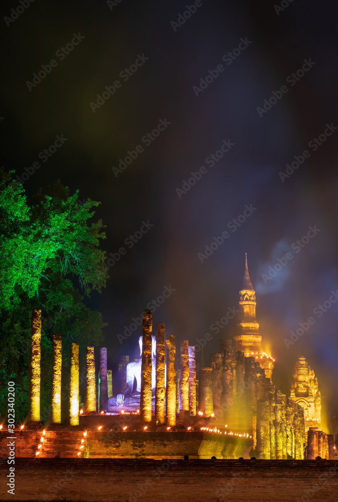 Old Buddhist temple at night with lights and smoke.