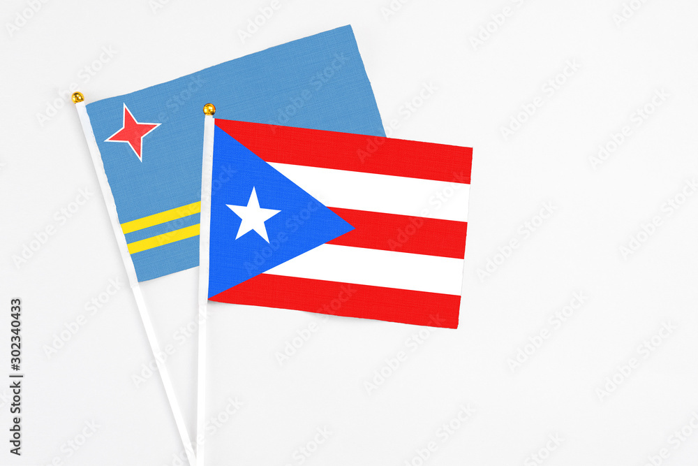 Puerto Rico and Aruba stick flags on white background. High quality fabric, miniature national flag. Peaceful global concept.White floor for copy space.