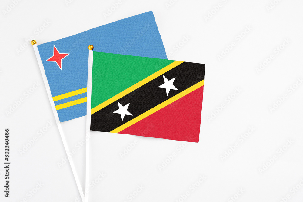 Saint Kitts And Nevis and Aruba stick flags on white background. High quality fabric, miniature national flag. Peaceful global concept.White floor for copy space. Saint Kitts And Nevis and Aruba stick flags on white background. High quality fabric, miniature national flag. Peaceful global concept.White floor for copy space.