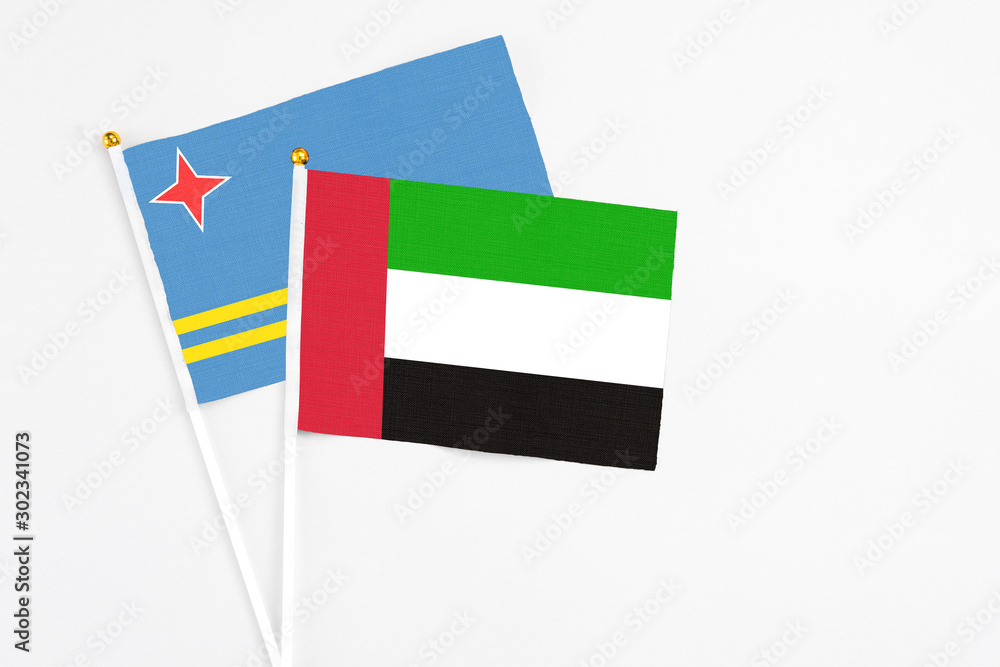 United Arab Emirates and Aruba stick flags on white background. High quality fabric, miniature national flag. Peaceful global concept.White floor for copy space. United Arab Emirates and Aruba stick flags on white background. High quality fabric, miniature national flag. Peaceful global concept.White floor for copy space.