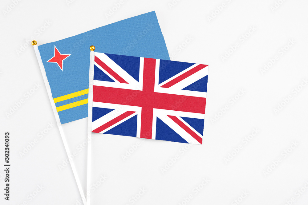 United Kingdom and Aruba stick flags on white background. High quality fabric, miniature national flag. Peaceful global concept.White floor for copy space. United Kingdom and Aruba stick flags on white background. High quality fabric, miniature national flag. Peaceful global concept.White floor for copy space.