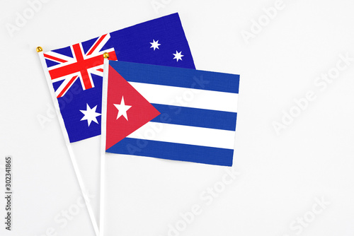 Cuba and Australia stick flags on white background. High quality fabric, miniature national flag. Peaceful global concept.White floor for copy space. photo