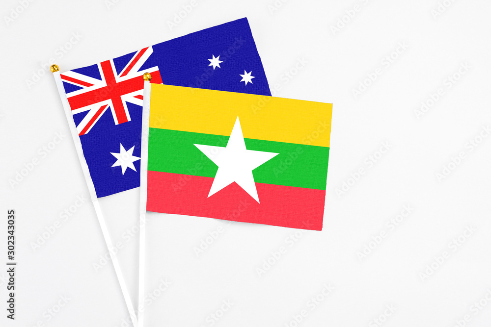 Fototapeta premium Myanmar and Australia stick flags on white background. High quality fabric, miniature national flag. Peaceful global concept.White floor for copy space.
