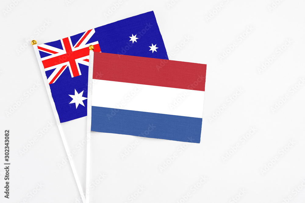 Netherlands and Australia stick flags on white background. High quality fabric, miniature national flag. Peaceful global concept.White floor for copy space. Netherlands and Australia stick flags on white background. High quality fabric, miniature national flag. Peaceful global concept.White floor for copy space.