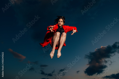 Freedom, beautiful girl jumping high in the sky