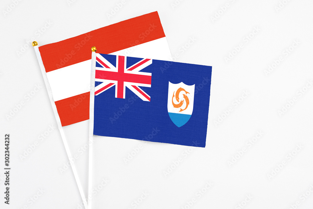 Anguilla and Austria stick flags on white background. High quality fabric, miniature national flag. Peaceful global concept.White floor for copy space.