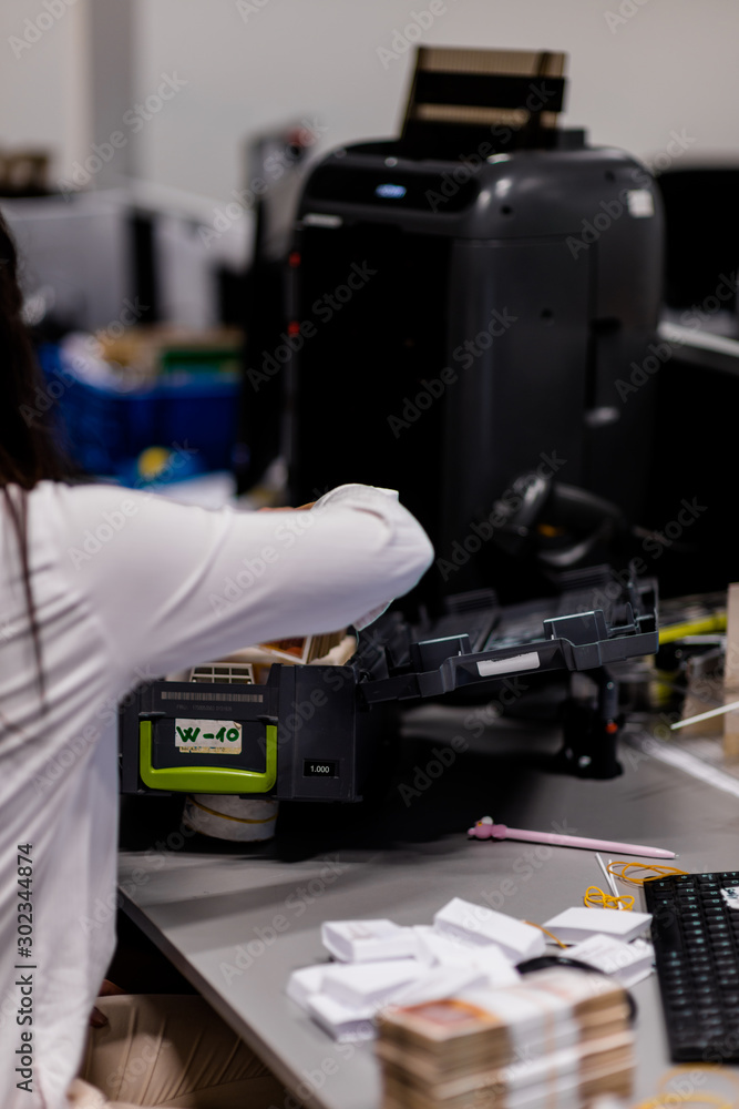 Office woman arranging stacks of money into box Office woman arranging stacks of money into box