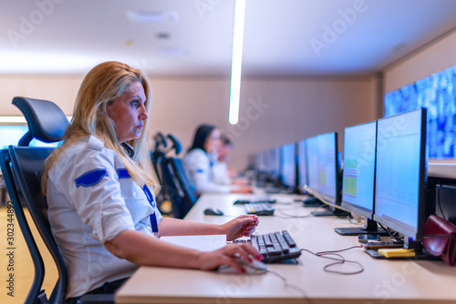 Female security operator working in a security  data control room offices