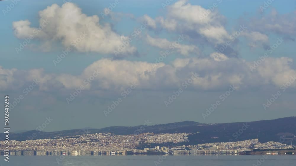 Thessaloniki, Greece landscape coastal view of east city area with clouds above. Day view of the capital of the Central Macedonia Greek administrative region with buildings seen on the Thermaic Gulf. Thessaloniki, Greece landscape coastal view of east city area with clouds above. Day view of the capital of the Central Macedonia Greek administrative region with buildings seen on the Thermaic Gulf.