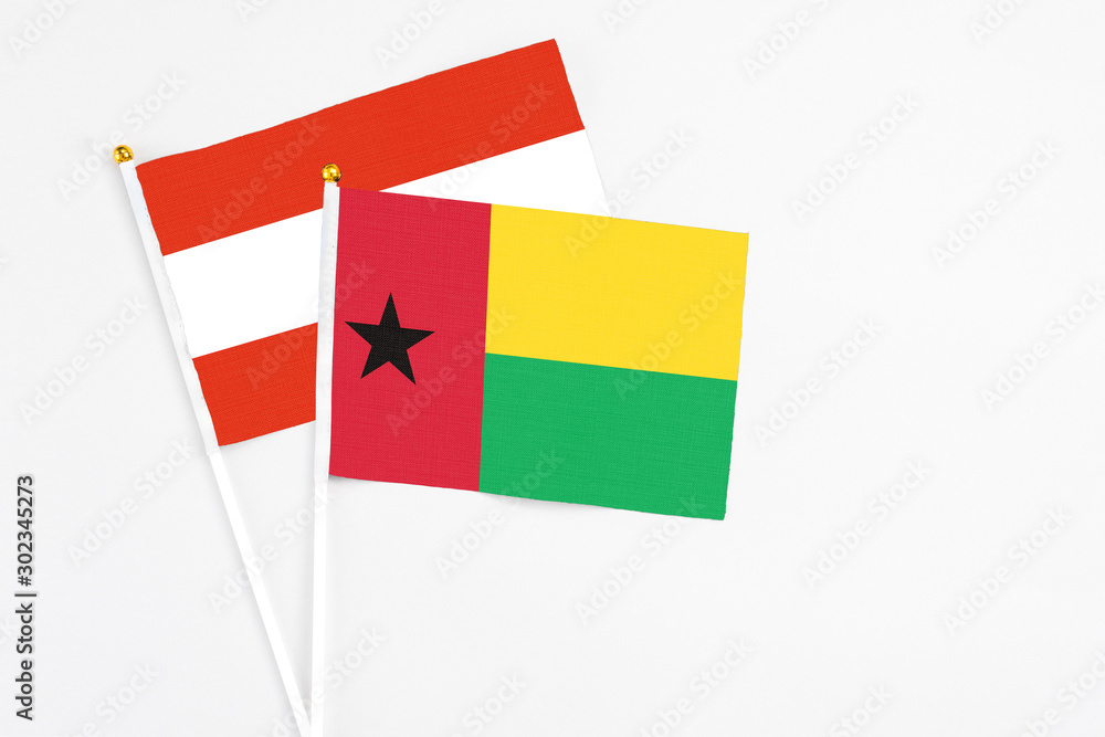 Guinea Bissau and Austria stick flags on white background. High quality fabric, miniature national flag. Peaceful global concept.White floor for copy space. Guinea Bissau and Austria stick flags on white background. High quality fabric, miniature national flag. Peaceful global concept.White floor for copy space.