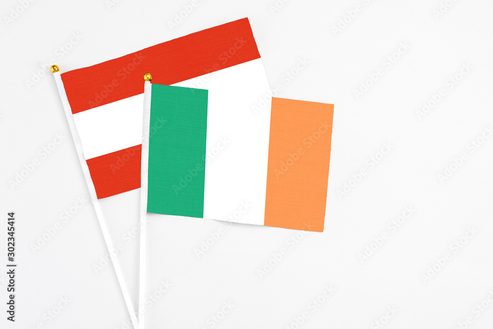 Ireland and Austria stick flags on white background. High quality fabric, miniature national flag. Peaceful global concept.White floor for copy space. Ireland and Austria stick flags on white background. High quality fabric, miniature national flag. Peaceful global concept.White floor for copy space.