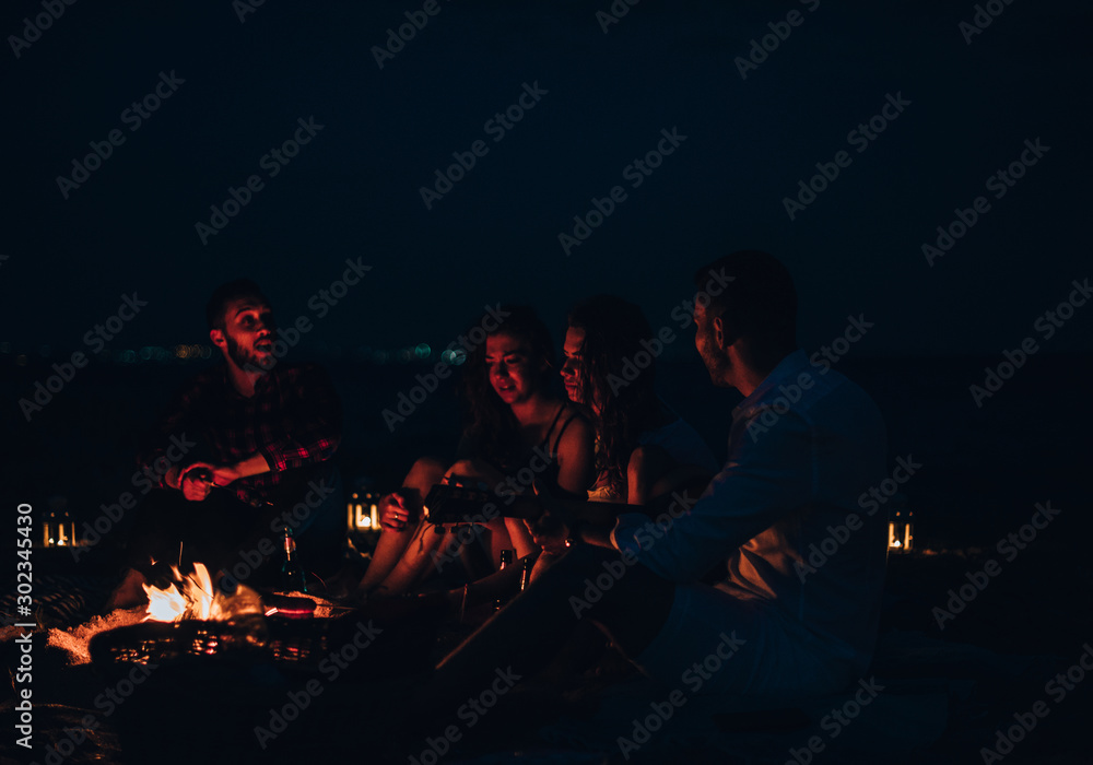 The happy people warming hands near the bonfire. night time The happy people warming hands near the bonfire. night time