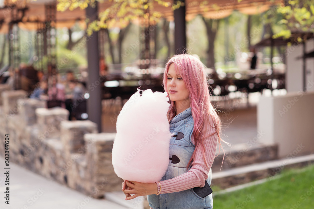 Adorable young woman with long pink hair eats and poses with sugar pink candy  cotton. Concept happy times. Carefree girl. Good mood Stock Photo | Adobe  Stock