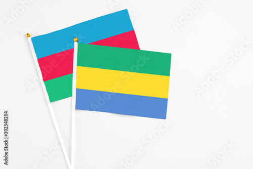 Gabon and Azerbaijan stick flags on white background. High quality fabric  miniature national flag. Peaceful global concept.White floor for copy space.