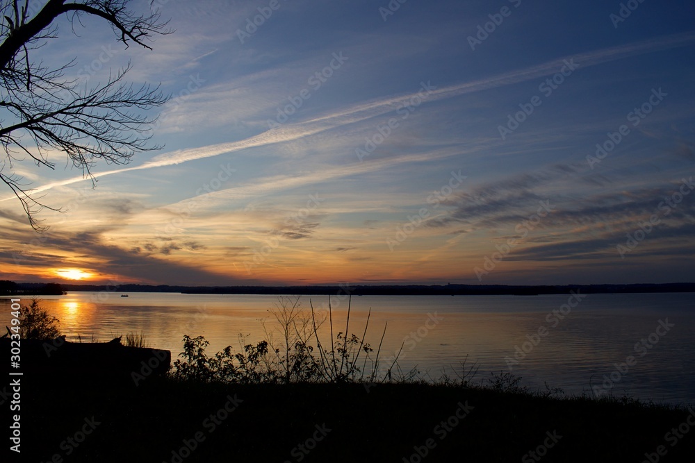 Sunset over Bay of Water with silhouette shoreline Sunset over Bay of Water with silhouette shoreline