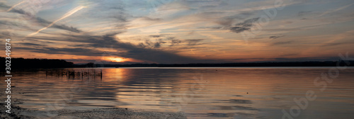 Sunset over Bay of Water with silhouette shoreline, wide angle view
