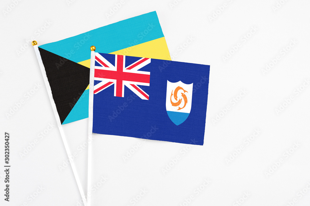 Fototapeta premium Anguilla and Bahamas stick flags on white background. High quality fabric, miniature national flag. Peaceful global concept.White floor for copy space.