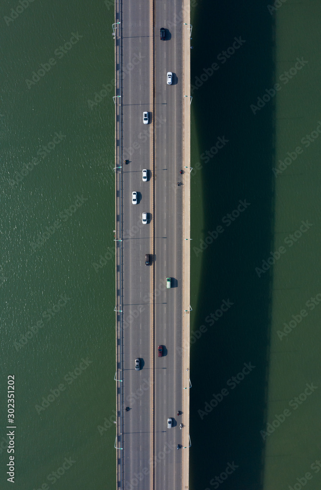 Fototapeta premium Car driving on the bridge across the river top view