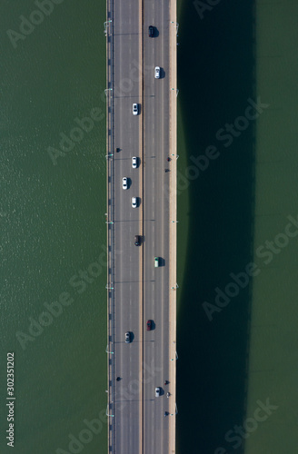 Car driving on the bridge across the river top view