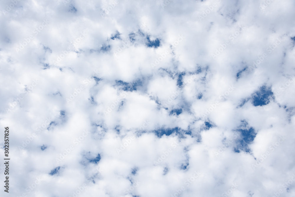 Small puffy white cloud pattern with glimpses of blue sky as a nature background Small puffy white cloud pattern with glimpses of blue sky as a nature background
