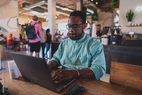 man working on tablet computer in cafe