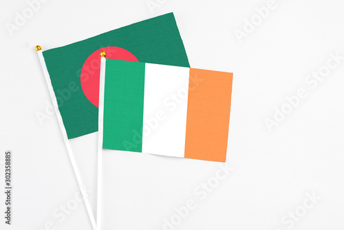 Ireland and Bangladesh stick flags on white background. High quality fabric, miniature national flag. Peaceful global concept.White floor for copy space. photo