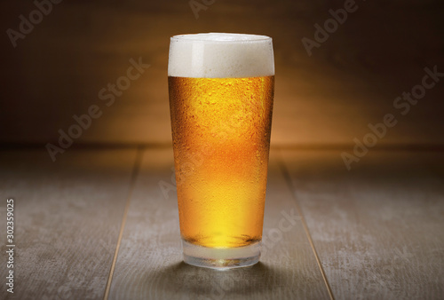 Obraz na plátně Beautiful colorful glass of IPA beer served on retro wooden surface, ale, golden
