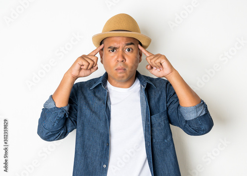 Asian men around the age of 27-35 are thinking and making faces, confused, not understanding, wondering with something.With a white background He wears a white shirt and jean shirt.