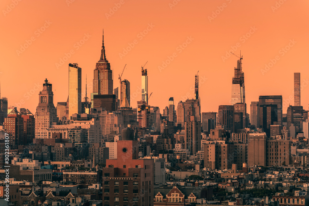 Naklejka premium Sunset above Manhattan skyscrapers, New York City. Light effect applied