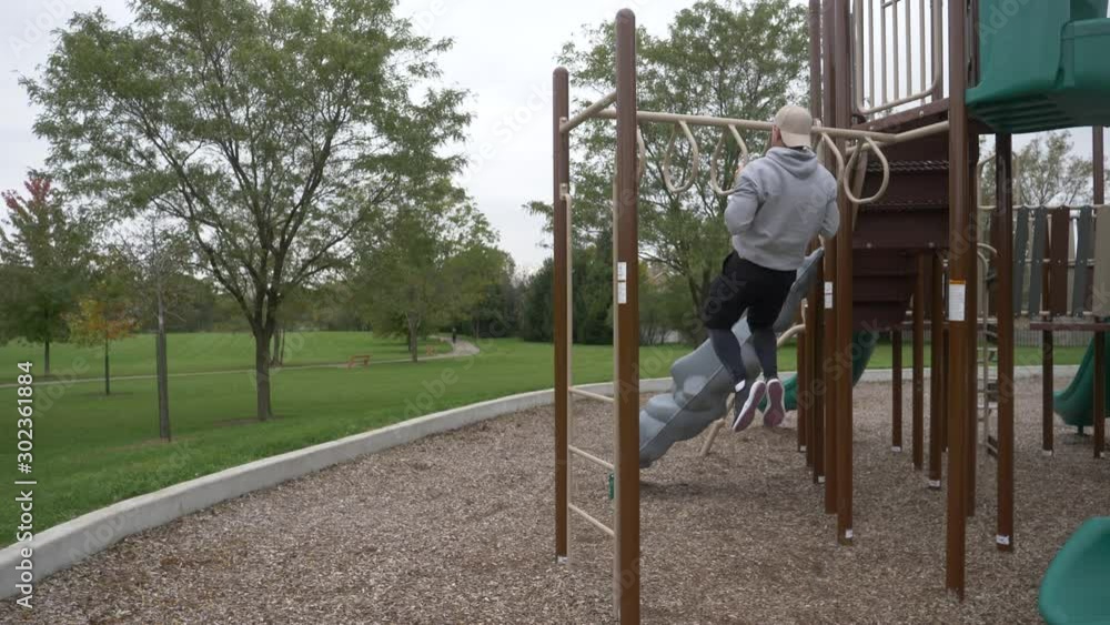 Man exercising, training, working out, doing pull ups in the park. Man exercising, training, working out, doing pull ups in the park.