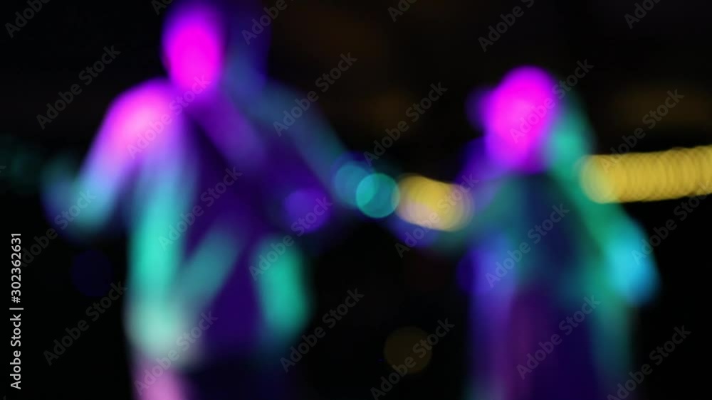 Back view of country and western band on stage under lights. Shallow focus shifts from a guitar headstock in the foreground to the band Back view of country and western band on stage under lights. Shallow focus shifts from a guitar headstock in the foreground to the band