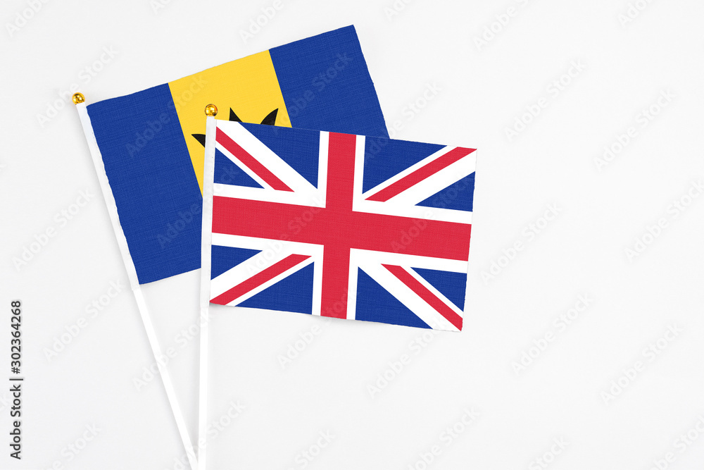 Fototapeta premium United Kingdom and Barbados stick flags on white background. High quality fabric, miniature national flag. Peaceful global concept.White floor for copy space.