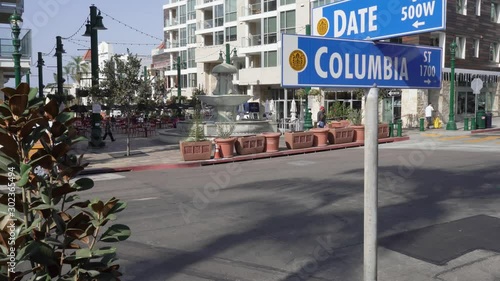 Date and columbia street corner sign in San Diego city. In front of Little Italy piazza Della Famiglia fountain