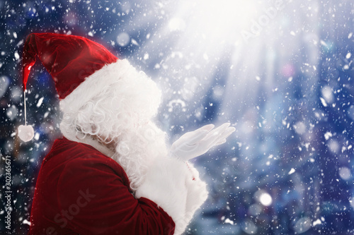 Santa Claus with magic Christmas lights