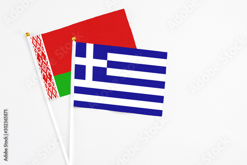 Greece and Belarus stick flags on white background. High quality fabric, miniature national flag. Peaceful global concept.White floor for copy space. photo