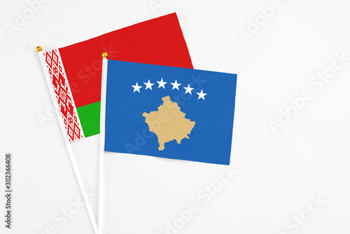 Kosovo and Belarus stick flags on white background. High quality fabric, miniature national flag. Peaceful global concept.White floor for copy space. photo