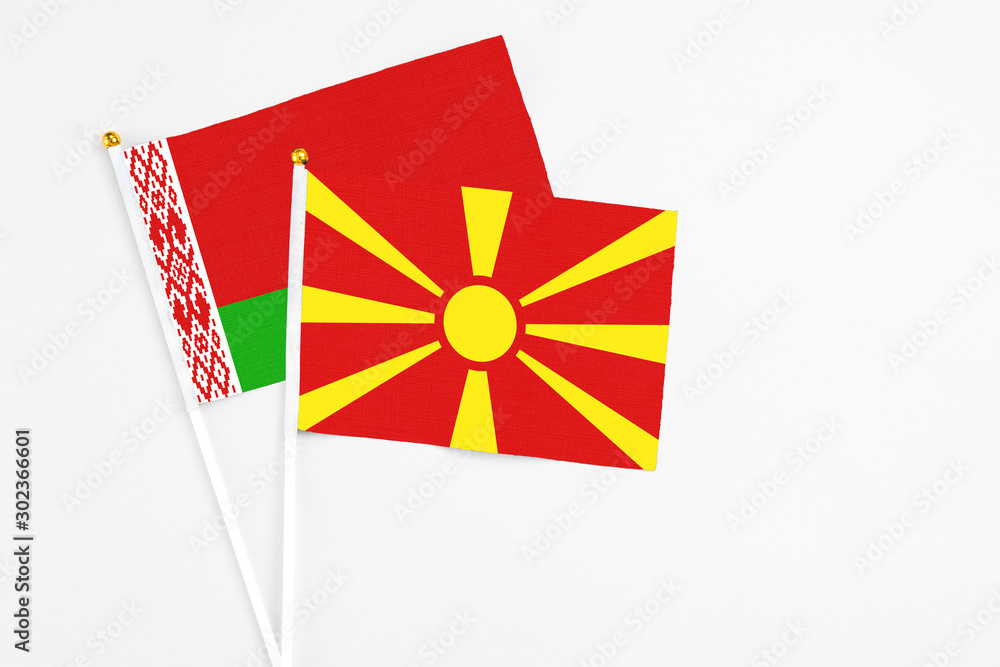 Macedonia and Belarus stick flags on white background. High quality fabric, miniature national flag. Peaceful global concept.White floor for copy space.
